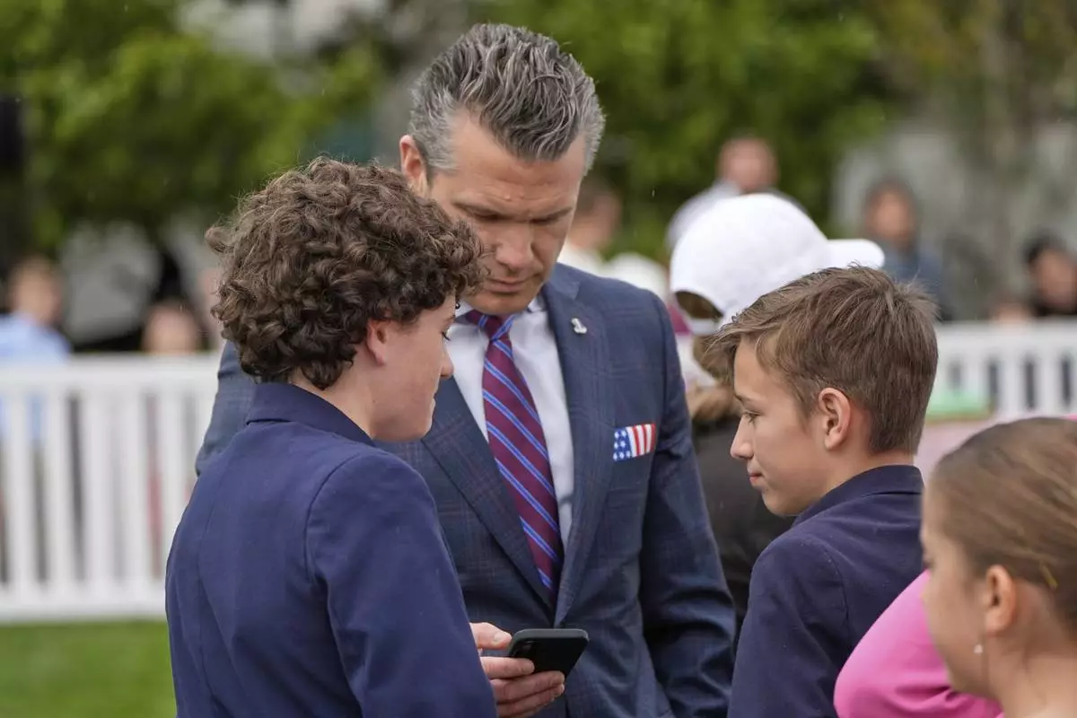 Defense Secretary Pete Hegseth looks at his phone on the South Lawn of the White House before President Donald Trump and first lady Melania Trump participate in the White House Easter Egg Roll Monday, April 21, 2025, in Washington. (AP Photo/Alex Brandon)