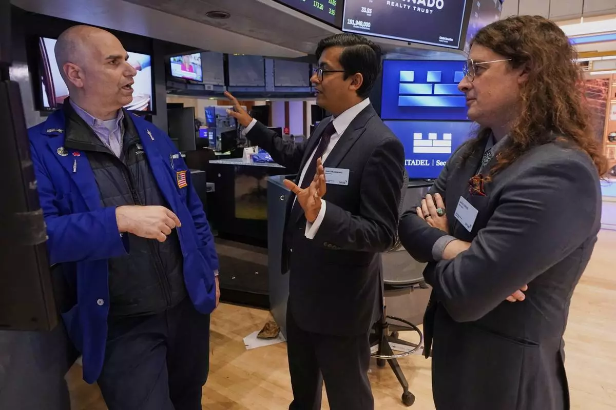 XPRIZE Carbon Removal winners from Mati Carbon, Founder & CEO Shantanu Agarwal, center, and Chief Science Officer Jake Jordan, right, talk with Specialist Philip Finale during their visit to the trading floor of the New York Stock Exchange, Tuesday, April 22, 2025. (AP Photo/Richard Drew)