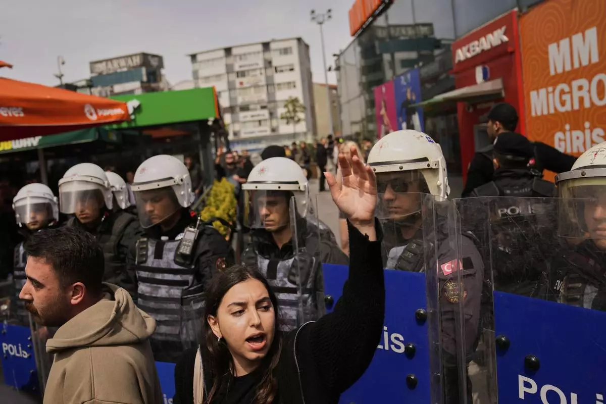 A woman shouts slogans during a protest outside Caglayan courthouse, in Istanbul, Turkey, Friday, April 18, 2025, during the hearing of dozens of people accused of attending banned demonstrations after the arrest of Istanbul's Mayor Ekrem Imamoglu. (AP Photo/Khalil Hamra)