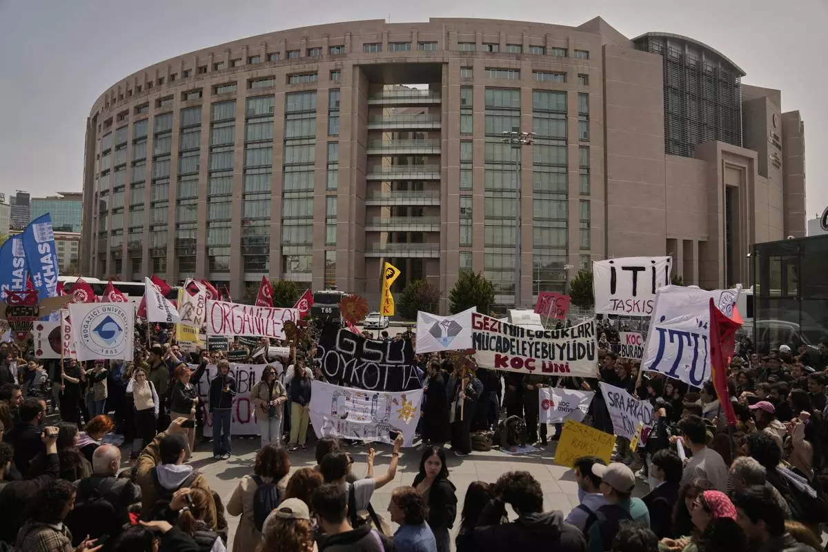 People gather to protest outside Caglayan courthouse, in Istanbul, Turkey, Friday, April 18, 2025, during the hearing of dozens of people accused of attending banned demonstrations after the arrest of Istanbul's Mayor Ekrem Imamoglu. (AP Photo/Khalil Hamra)