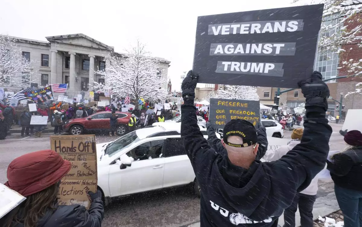 Protesters brave the wintery weather as they demontrate along North Nevada Avenue in Colorado Springs, Colo., Saturday, April 19, 2025, during a local Day of Action and Protest! demonstration outside the Colorado Springs City Hall. (Christian Murdock/The Gazette via AP)