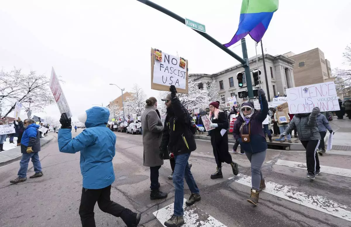 Demonstrators march in downtown Colorado Springs, Colo., Saturday, April 19, 2025, during a local Day of Action and Protest! demonstration outside the Colorado Springs City Hall. (Christian Murdock/The Gazette via AP)