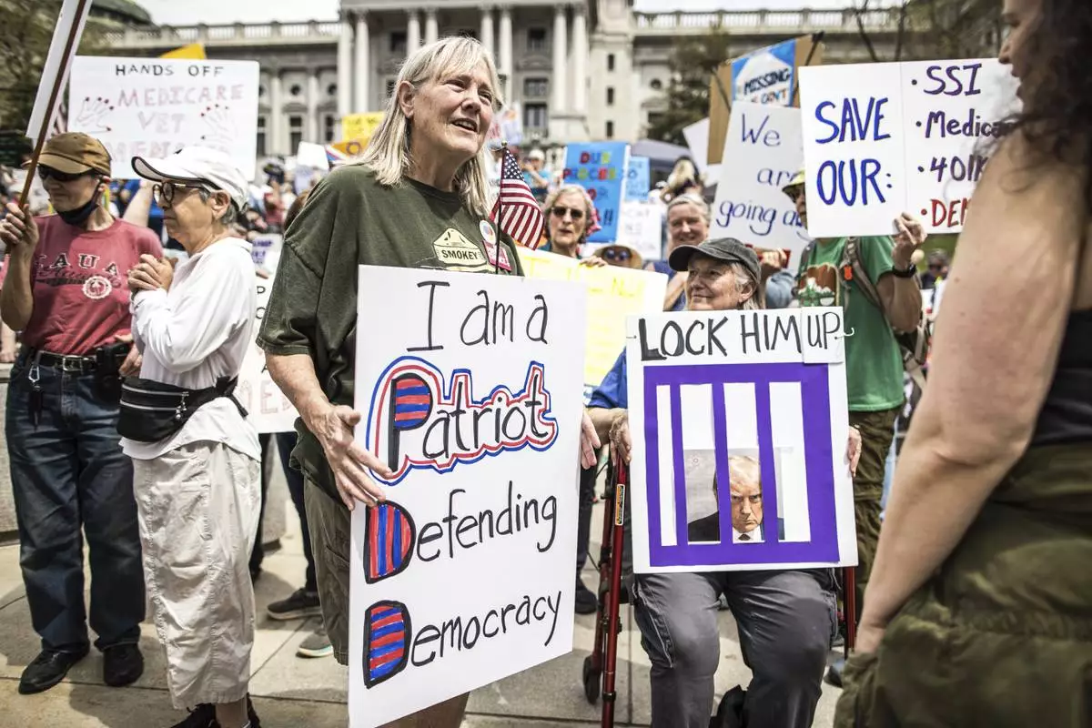 Protesters rally at the state capitol in Harrisburg, Pa., during the Day of Action protest against the Trump Administration. Saturday, April 19, 2025. (Zach Gleiter/The Patriot-News via AP)