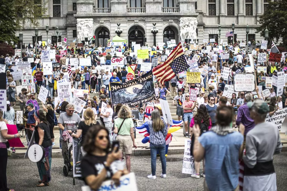 Protesters rally at the state capitol in Harrisburg, Pa., during the Day of Action protest against the Trump Administration. Saturday, April 19, 2025. (Zach Gleiter/The Patriot-News via AP)