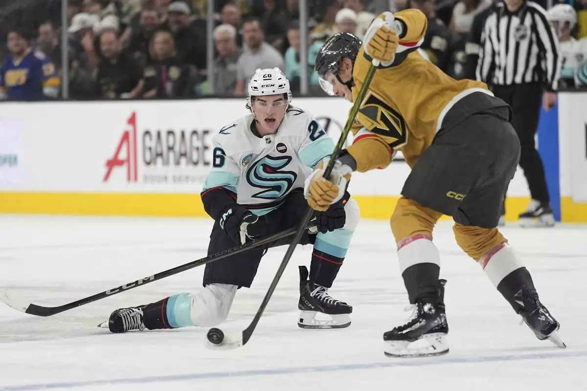 Seattle Kraken center Ryan Winterton (26) sttempts to sopt a pass by Vegas Golden Knights defenseman Kaedan Korczak (6) during the first period of an NHL hockey game Thursday, April 10, 2025, in Las Vegas. (AP Photo/John Locher)