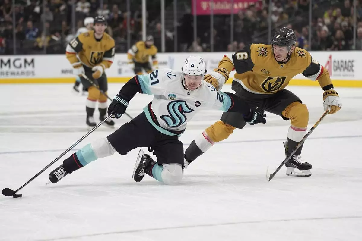 Seattle Kraken center Michael Eyssimont (21) attempts to skate around Vegas Golden Knights defenseman Kaedan Korczak (6) during the first period of an NHL hockey game Thursday, April 10, 2025, in Las Vegas. (AP Photo/John Locher)