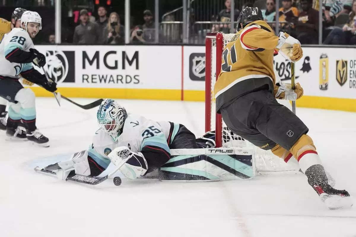 Seattle Kraken goaltender Joey Daccord (35) stops a shot by Vegas Golden Knights center Brett Howden (21) during the second period of an NHL hockey game Thursday, April 10, 2025, in Las Vegas. (AP Photo/John Locher)