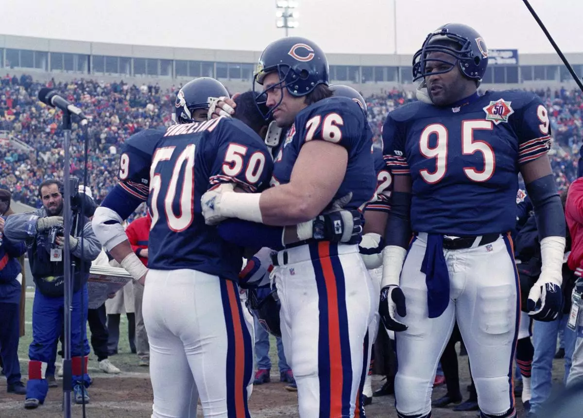 FILE - Chicago Bears nine-time Pro Bowler Mike Singletary (50) gets a bear hug from teammate Steve McMichael (76) prior to an NFL football game against the Pittsburgh Steelers in Chicago, Dec. 13, 1992. (AP Photo/David Boe, File)