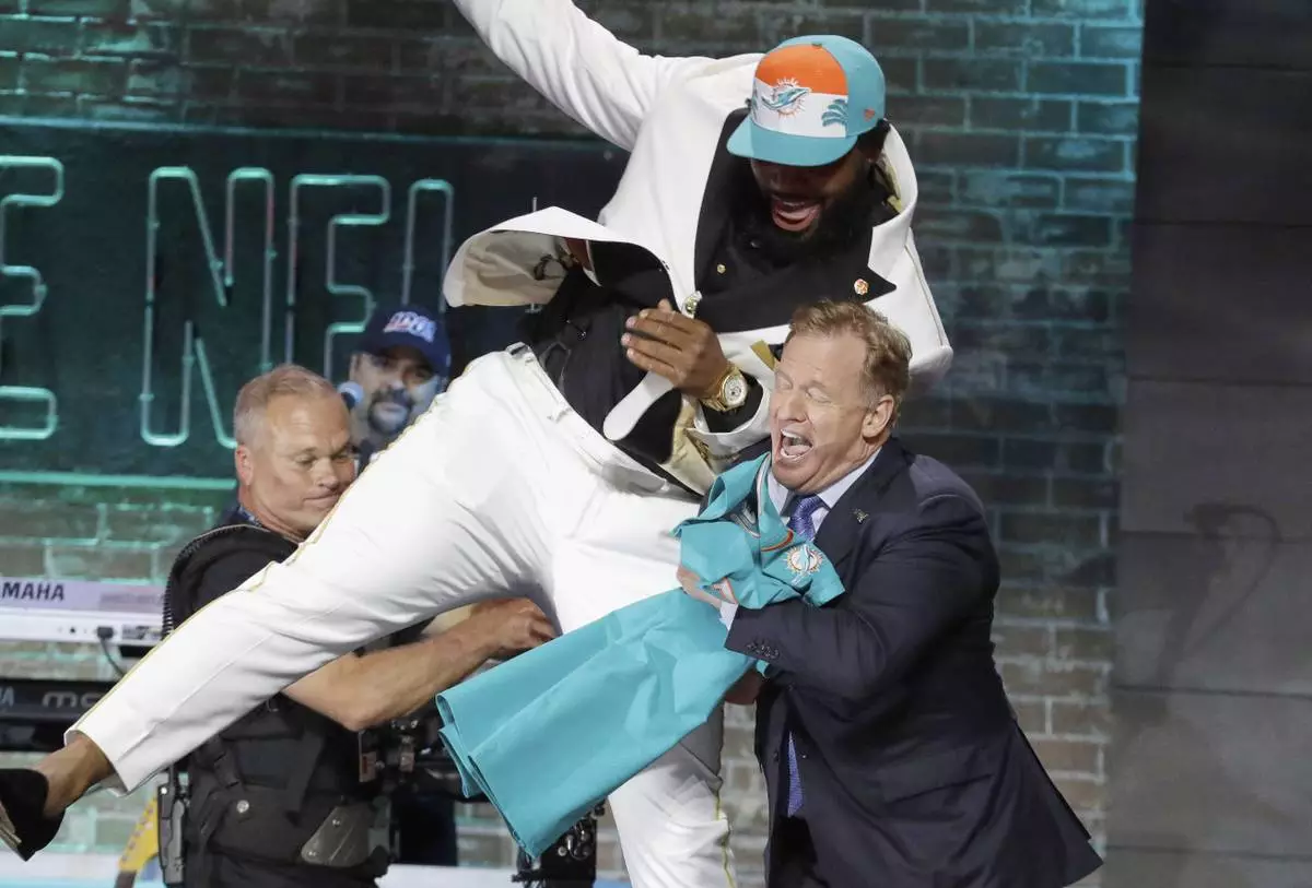 FILE - Clemson defensive tackle Christian Wilkins moves into NFL Commissioner Roger Goodell after the Miami Dolphins selected Wilkins in the first round at the NFL football draft in Nashville, Tenn. (AP Photo/Steve Helber, File)