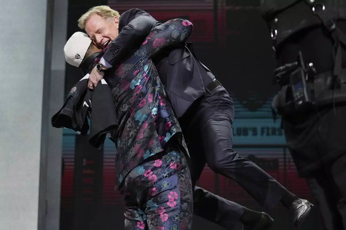 FILE - Texas Tech defensive lineman Tyree Wilson lifts up NFL Commissioner Roger Goodell after being chosen by the Las Vegas Raiders with the seventh overall pick during the first round of the NFL football draft, Thursday, April 27, 2023, in Kansas City, Mo. (AP Photo/Jeff Roberson, File)