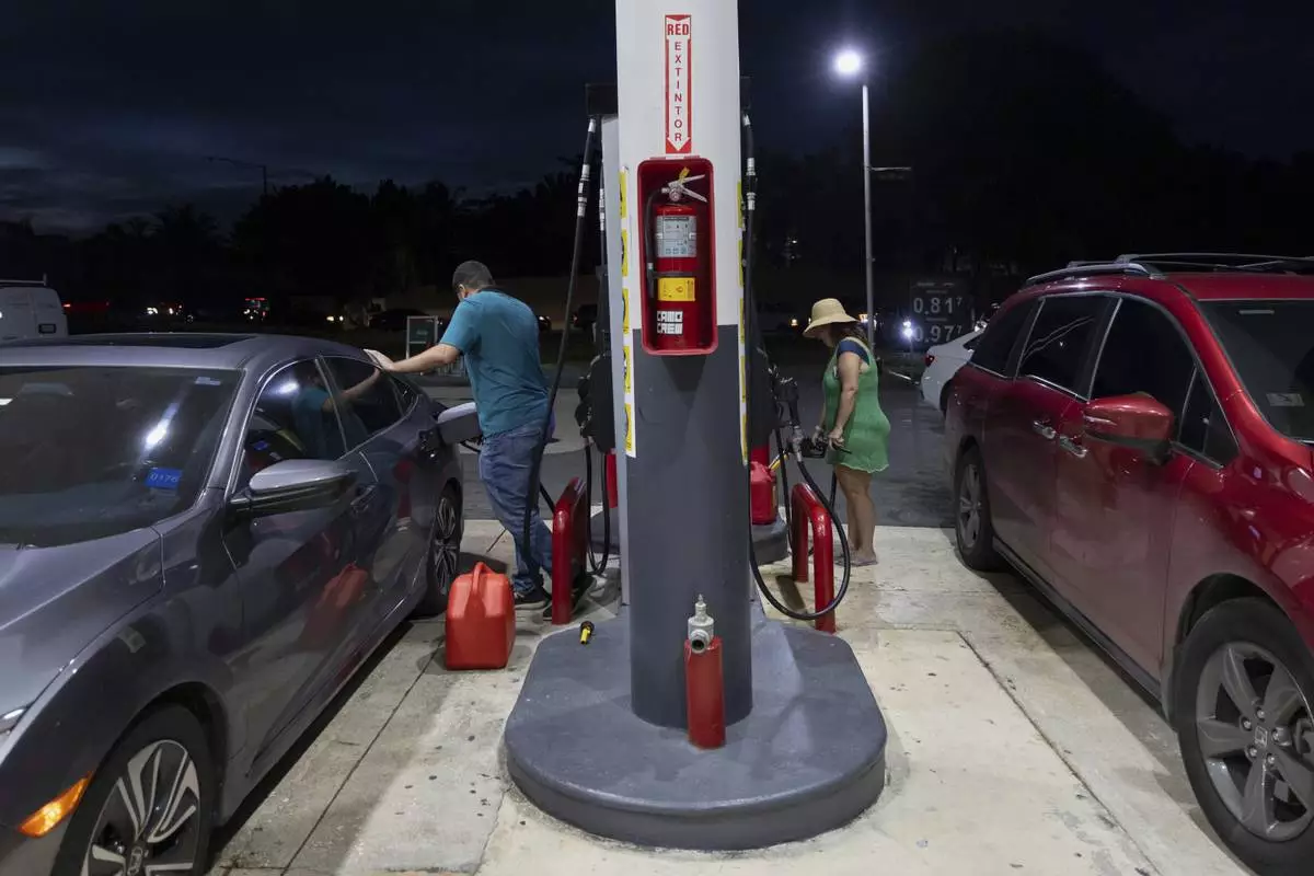 Drivers fill up fuel containers at a gas station during an island-wide blackout in San Juan, Puerto Rico, Wednesday, April 16, 2025. (AP Photo/Alejandro Granadillo)