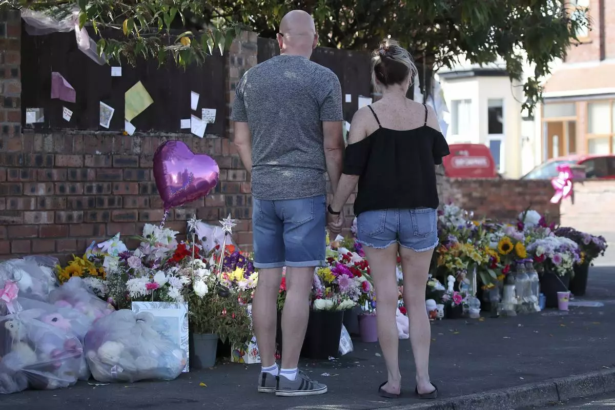 FILE - Floral tributes are left at the site in Southport, England, Sunday, Aug. 11, 2024 after three young girls were killed in a knife attack at a Taylor Swift-themed holiday club. (AP Photo/Scott Heppell, File)