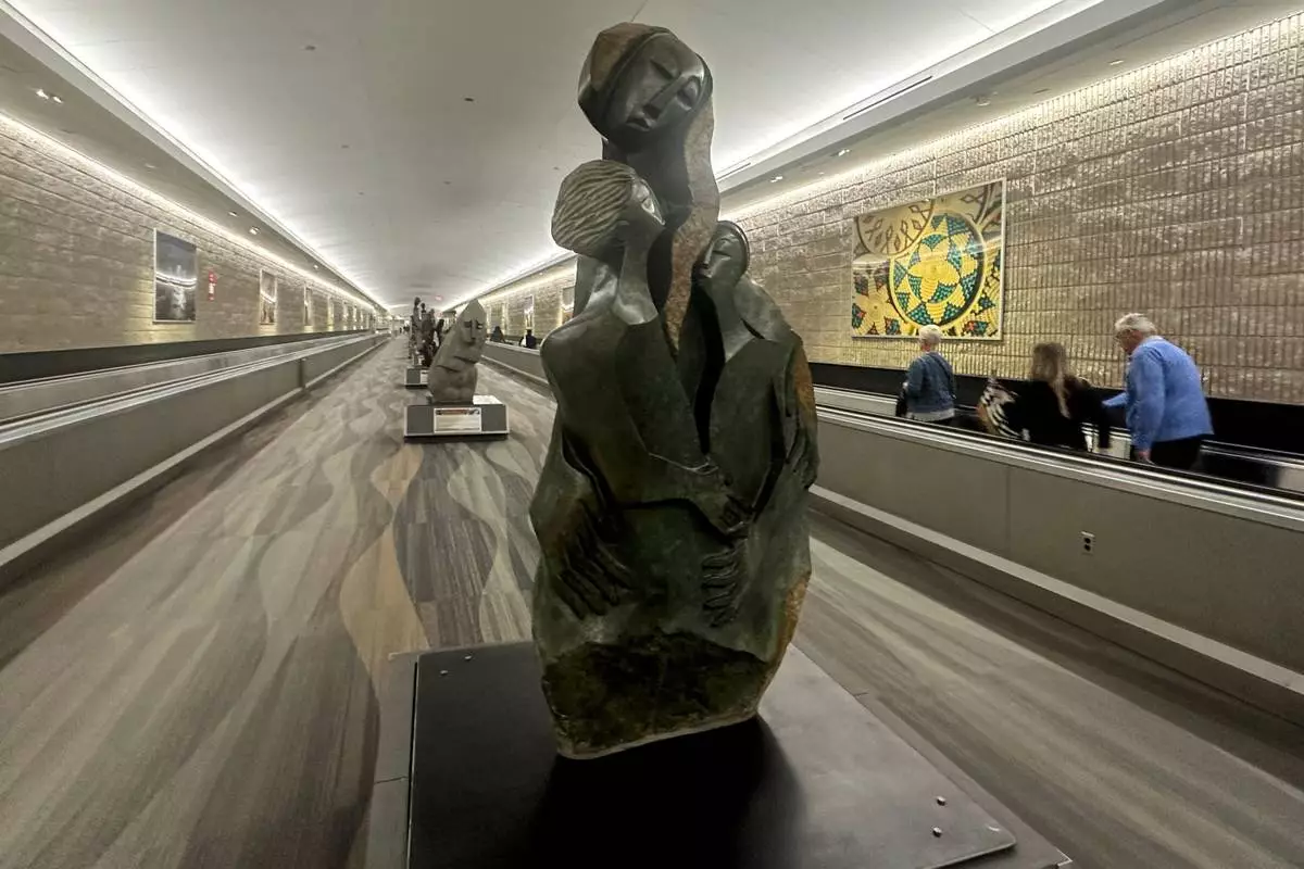 People walk by Zimbabwean sculpture piece at Hartsfield-Jackson Atlanta International Airport, Friday, Feb. 28, 2025, in Atlanta. (AP Photo/Ravi Nessman)