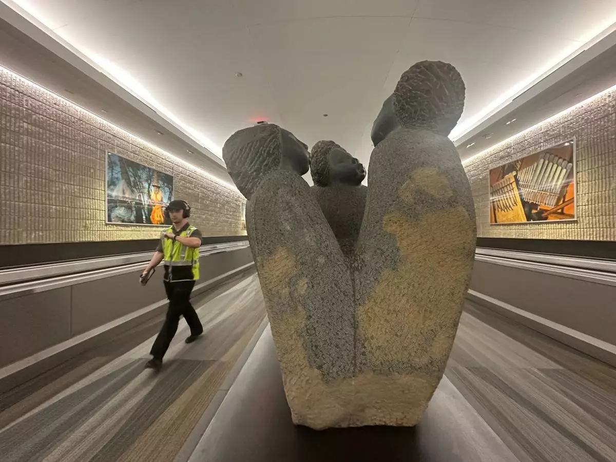 A person walks by a Zimbabwean stone art/sculpture piece at Hartsfield-Jackson Atlanta International Airport, Friday, Feb. 28, 2025, in Atlanta. (AP Photo/Ravi Nessman)