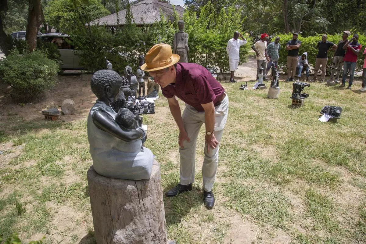 Richard Pantlin, founder of the Oxford Zimbabwe Arts Project, checks a sculpture that will be part of an upcoming exhibition at Oxford University aiming to contextualize the legacy of British imperialist Cecil John Rhodes, at the Chitungwiza Arts Centre near Harare, Zimbabwe, March 4, 2025. (AP Photo/Aaron Ufumeli)