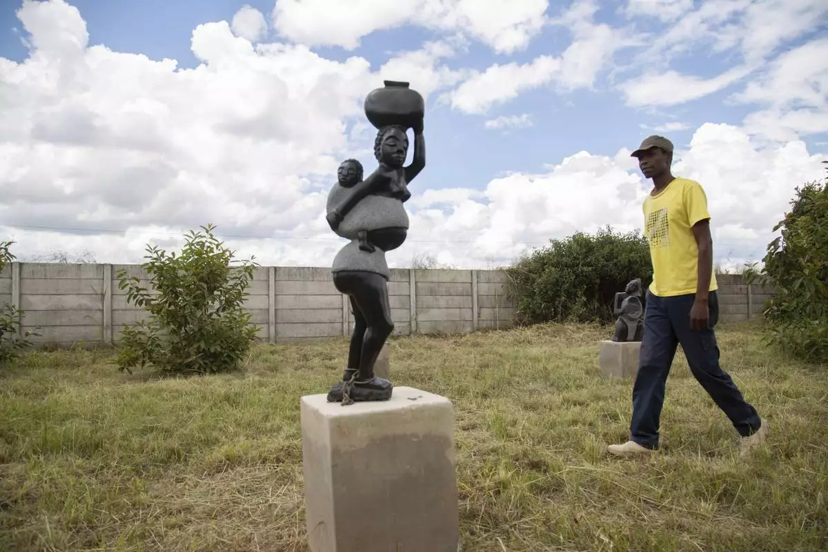 Derrick Fombe walks by his winning sculpture that will be part of an upcoming exhibition at Oxford University aiming to contextualize the legacy of British imperialist Cecil John Rhodes, at the Chitungwiza Arts Centre, near Harare, Zimbabwe, on March 8, 2025. (AP Photo/Aaron Ufumeli)