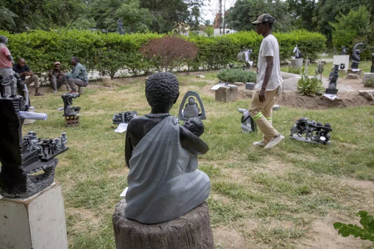 People walk past sculptures that will be part of an upcoming exhibition at Oxford University aiming to contextualize the legacy of British imperialist Cecil John Rhodes, at the Chitungwiza Arts Centre near Harare, Zimbabwe, Tuesday, March 4, 2025. (AP Photo/Aaron Ufumeli)