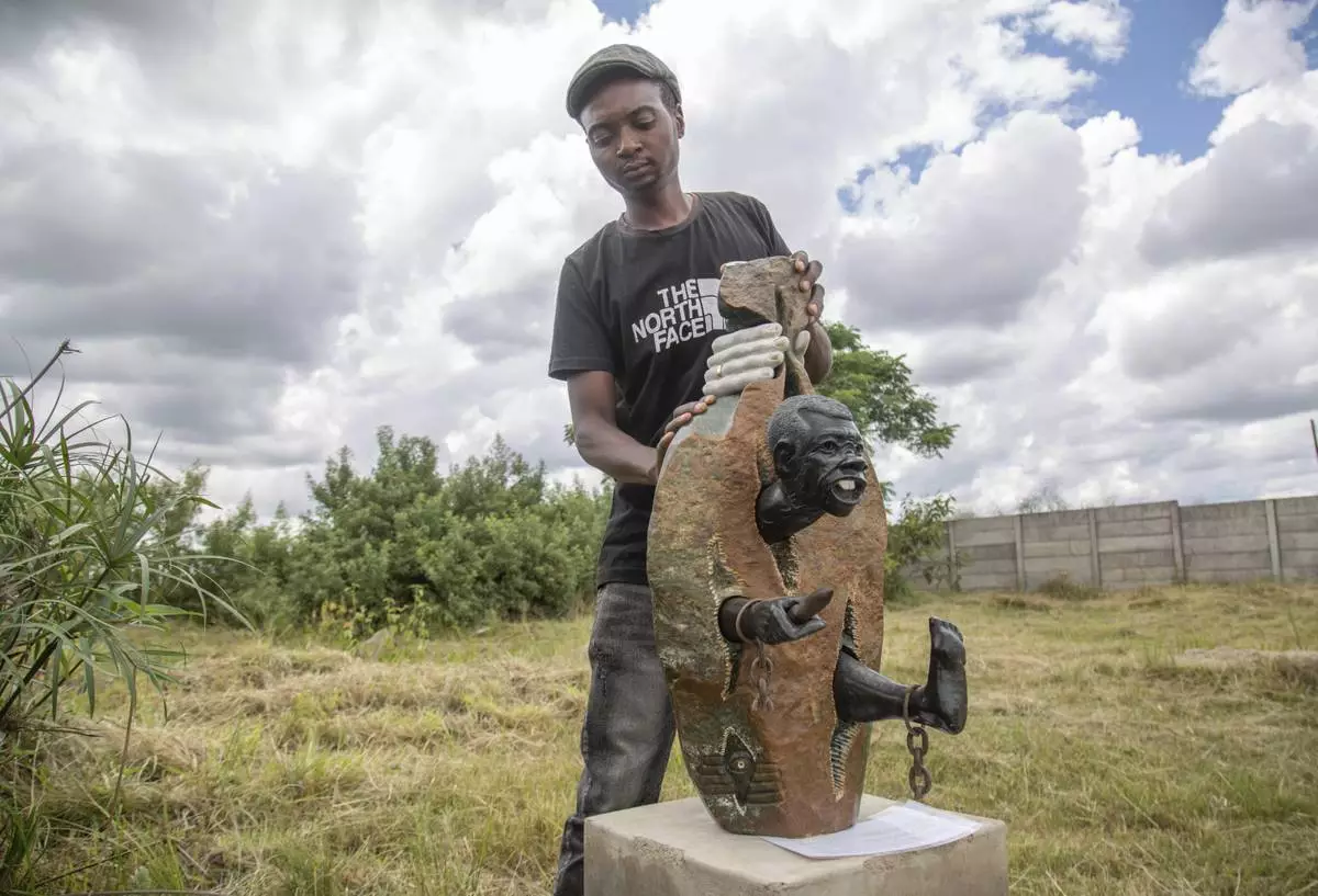 Gift Mutsauni holds his winning sculpture that will be part of an upcoming exhibition at Oxford University aiming to contextualize the legacy of British imperialist Cecil John Rhodes at the Chitungwiza Arts Centre near Harare, Zimbabwe, on March 8, 2025. (AP Photo/Aaron Ufumeli)