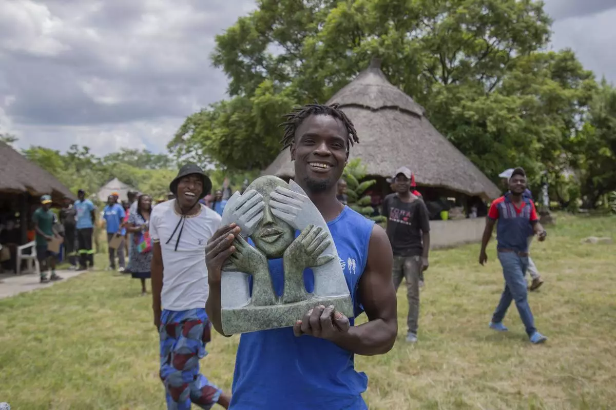 Wallace Mkanka holds his winning sculpture that will be part of an upcoming exhibition at Oxford University aiming to contextualize the legacy of British imperialist Cecil John Rhodes, at the Chitungwiza Arts Centre near Harare, Zimbabwe, on March 8, 2025. (AP Photo/Aaron Ufumeli)