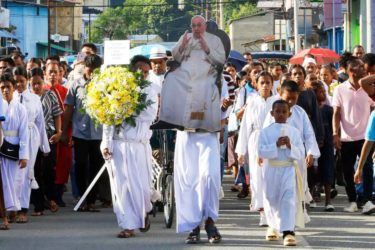 Devotees carry a cutout of the late Pope Francis during a procession ahead of a prayer in Dili, East Timor, Tuesday, April 22, 2025. (AP Photo/Lorenio L.Pereira)