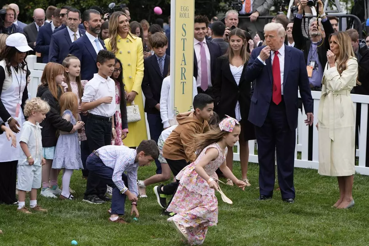 President Donald Trump and first lady Melania Trump blow whistles during the White House Easter Egg Roll on the South Lawn of the White House, Monday, April 21, 2025, in Washington. (AP Photo/Alex Brandon)