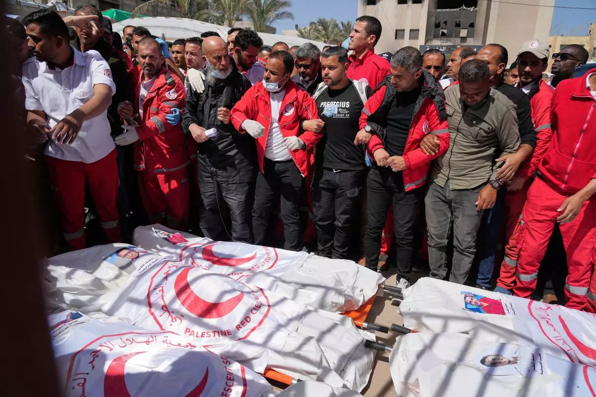 FILE.- Mourners gather around the bodies of 8 Red Crescent emergency responders, recovered in Rafah a week after an Israeli attack, as they are transported for burial from a hospital in Deir al-Balah, Gaza Strip, on Monday, March 31, 2025. (AP Photo/Abdel Kareem Hana, file)