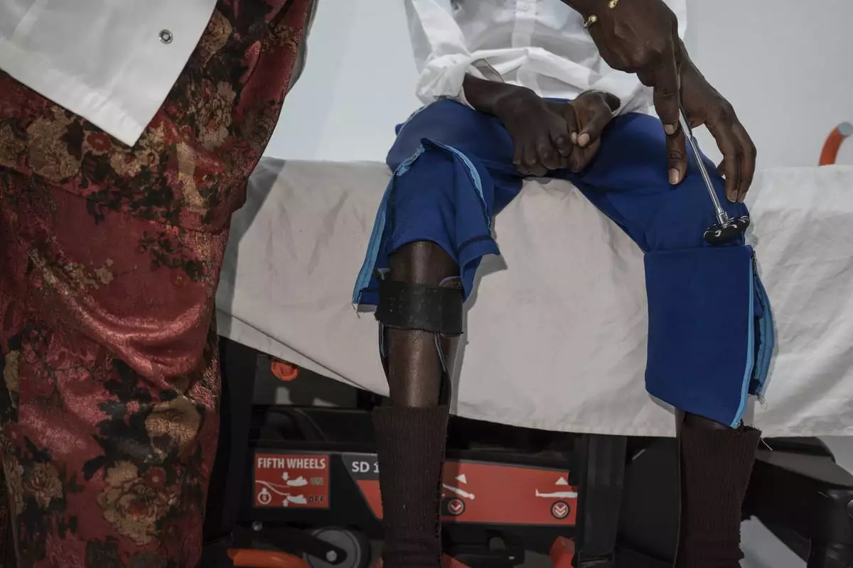 Neurology student Henriette Dieng examines Abdou Diop, a patient with genetic neuropathy at Pedro Rodriguez's clinic in Dakar, Senegal, Friday, Jan. 10, 2025. (AP Photo/Annika Hammerschlag)