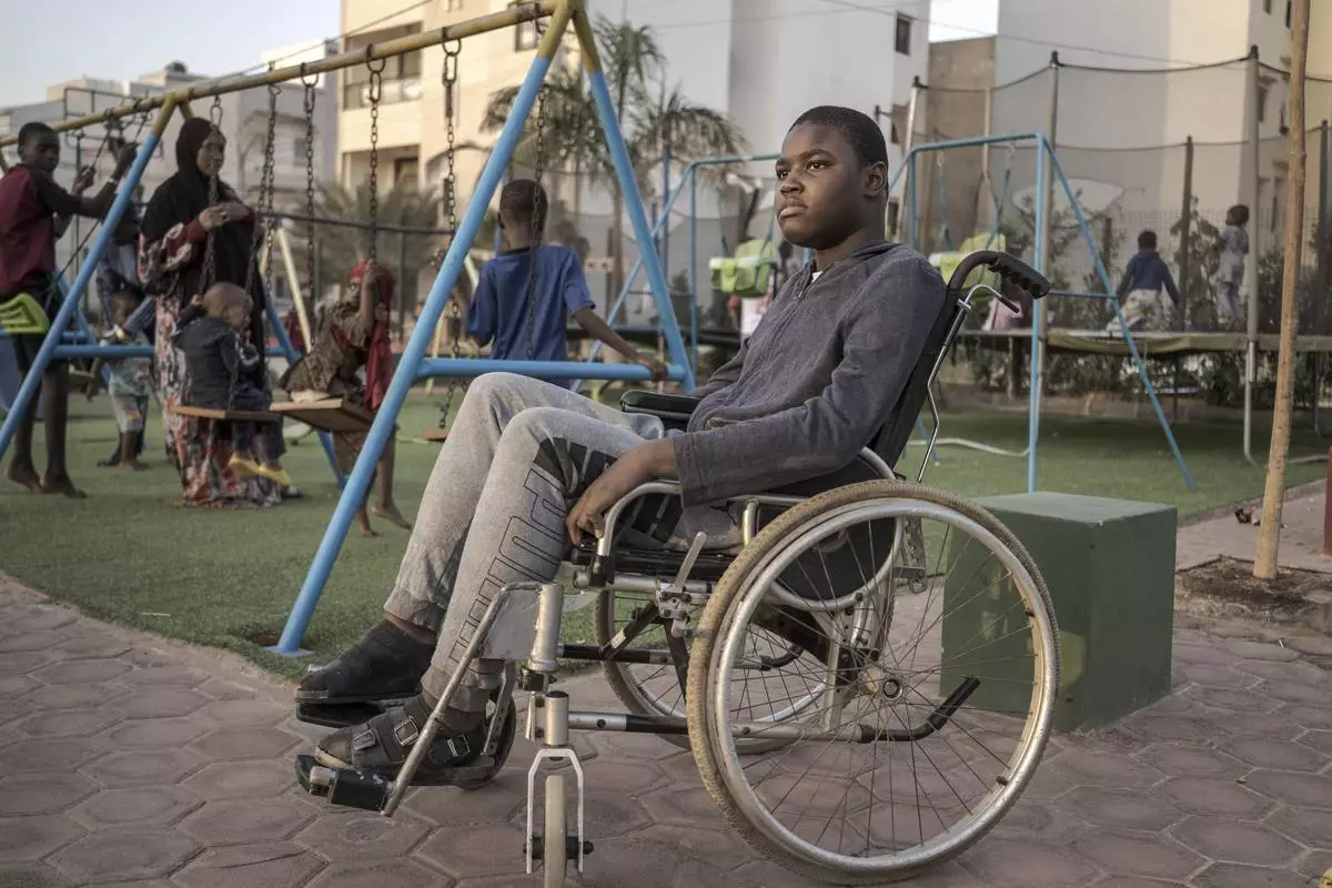 Mamadou, 13, watches children play in Dakar, Senegal, Saturday January 11, 2025. (AP Photo/Annika Hammerschlag)