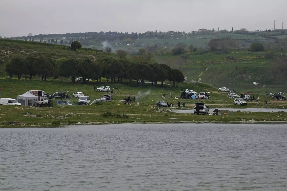 People gather outdoors away from urban areas following an earthquake shock with a preliminary magnitude of 6.2, in Istanbul, Turkey, Wednesday, April 23, 2025. (AP Photo/Khalil Hamra)