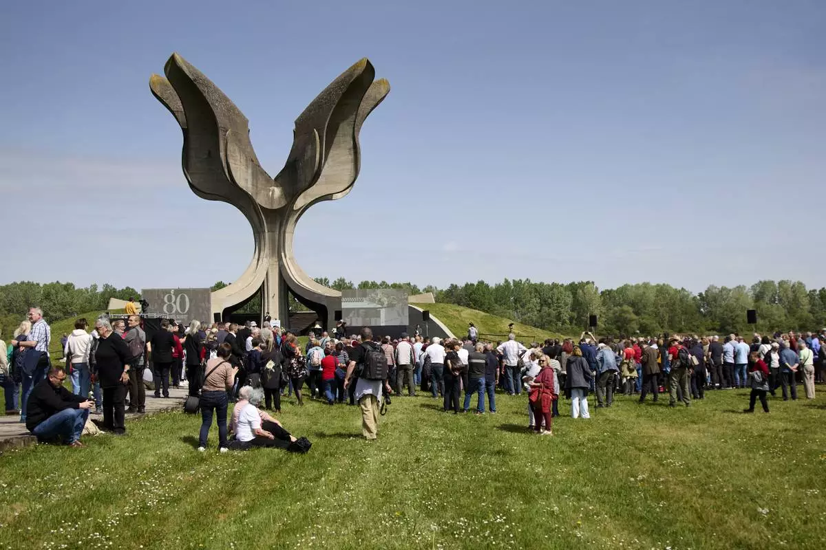 People gather around the monument commemorating victims of a World War II concentration camp, where tens of thousands of people perished in the hands of the pro-Nazi puppet regime at the time, in Jasenovac, Croatia, Tuesday, April 22, 2025. (AP Photo)