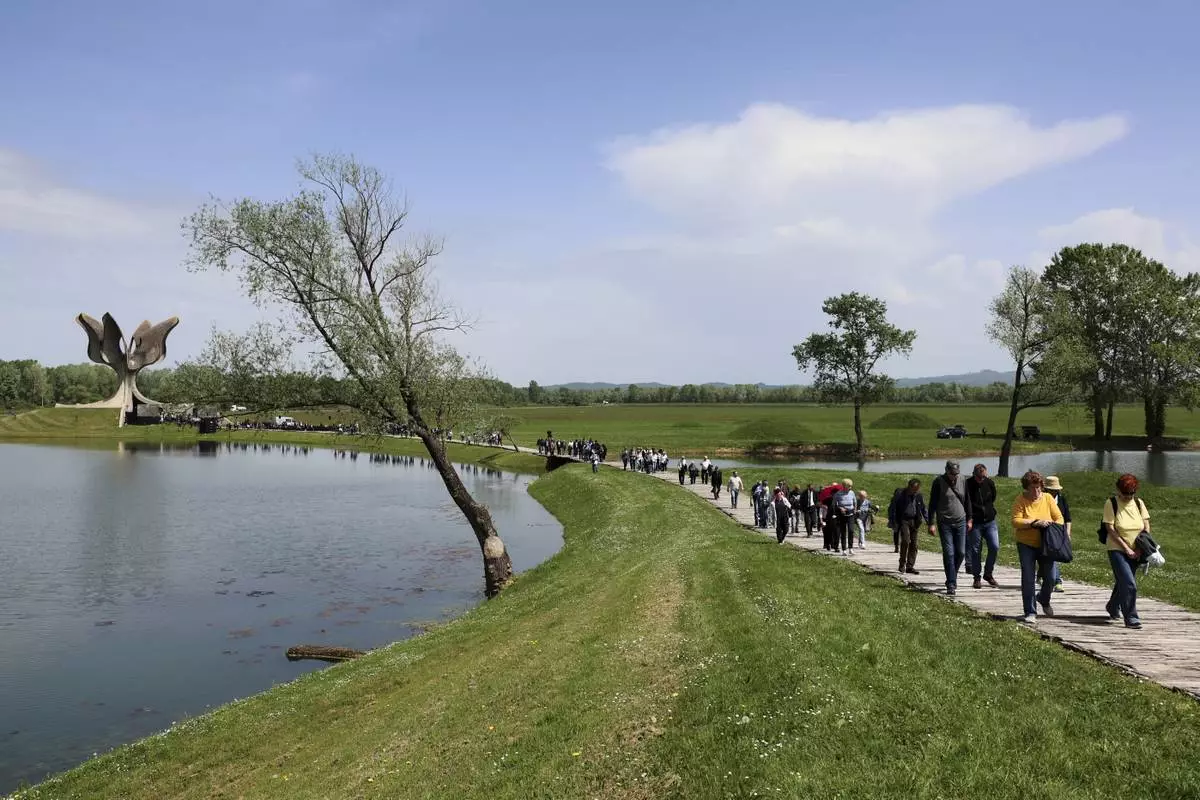 People walk away from the monument commemorating victims of a World War II concentration camp, where tens of thousands of people perished in the hands of the pro-Nazi puppet regime at the time, in Jasenovac, Croatia, Tuesday, April 22, 2025. (AP Photo)
