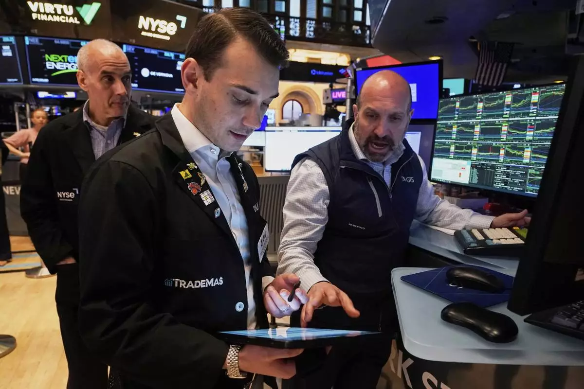 Specialist James Denaro, right, and trader Dylan Halvorsan, center, work on the floor of the New York Stock Exchange, Tuesday, April 22, 2025. (AP Photo/Richard Drew)