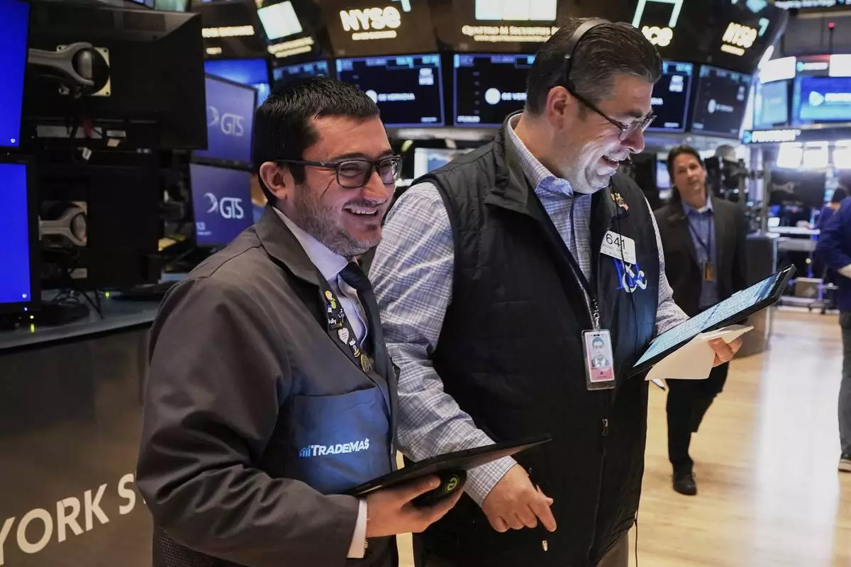 Traders Drew Cohen, left and Michael Capolino work on the floor of the New York Stock Exchange, Tuesday, April 22, 2025. (AP Photo/Richard Drew)