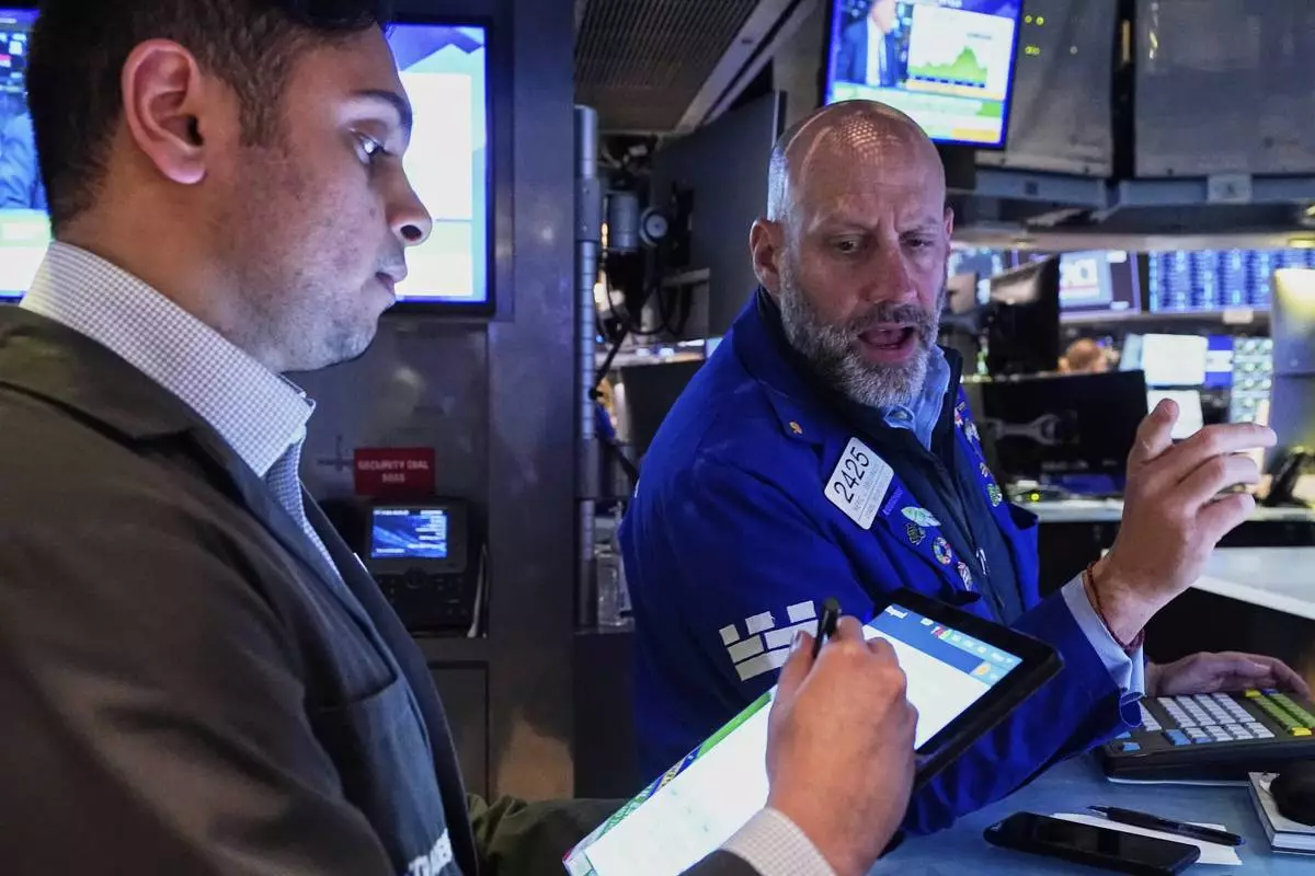 Trader Niall Pawa, left, and Specialist Meric Greenbaum work on the floor of the New York Stock Exchange, Wednesday, April 23, 2025. (AP Photo/Richard Drew)