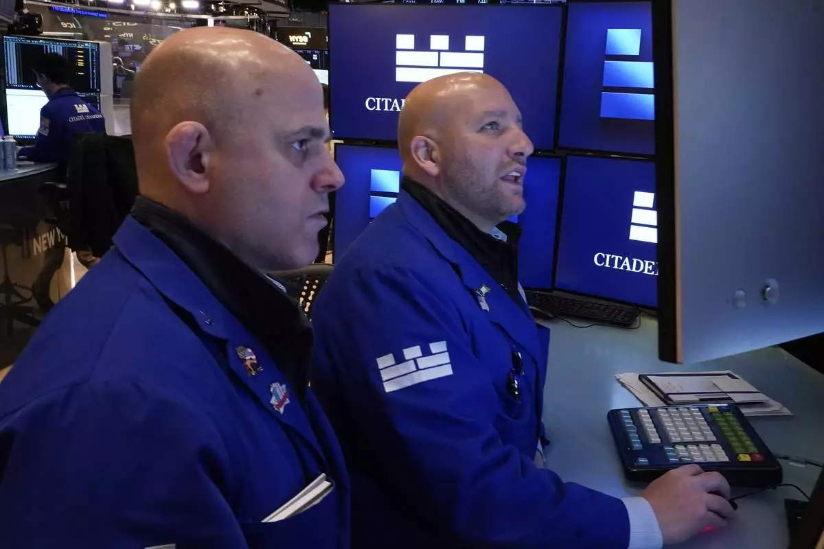 Specialists Mark Fitzgerald, left, and John Parisi confer on the floor of the New York Stock Exchange, Wednesday, April 23, 2025. (AP Photo/Richard Drew)