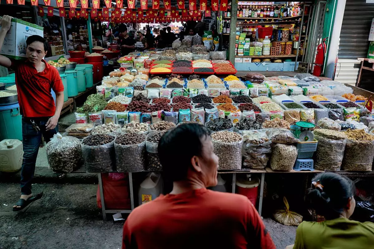 Spice and dried food vendors wait for customers at the Cholon market in the Cholon district of Ho Chi Minh City, Vietnam, on Tuesday, April 29, 2025 ahead of national celebration of the 50th Anniversary of reunification and the end of the Vietnam War. (AP Photo/Richard Vogel)