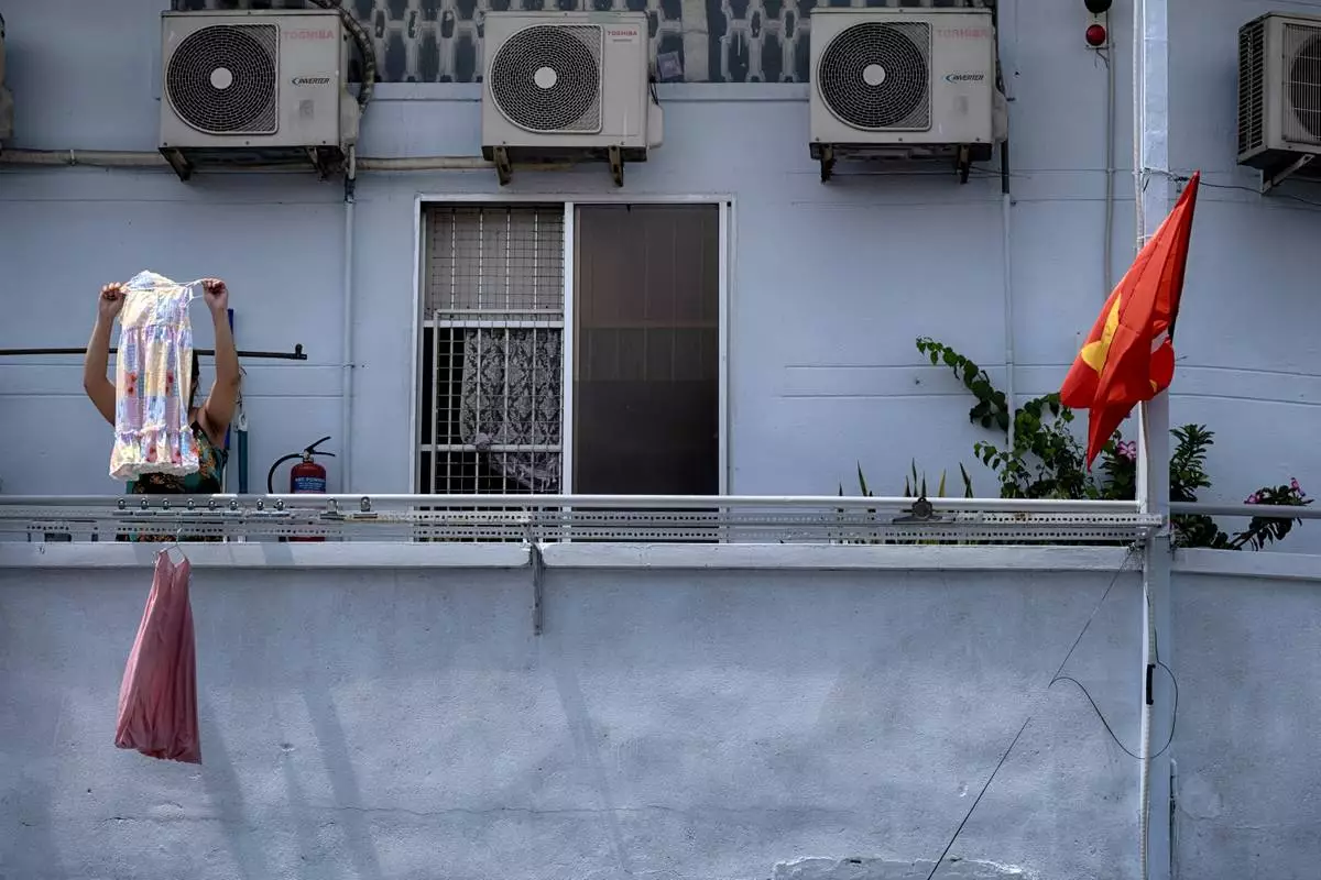 A woman hangs her laundry in the morning in the Cholon district of Ho Chi Minh City, Vietnam, on Tuesday, April 29, 2025 ahead of the 50th anniversary of the end of the Vietnamese War. (AP Photo/Richard Vogel)