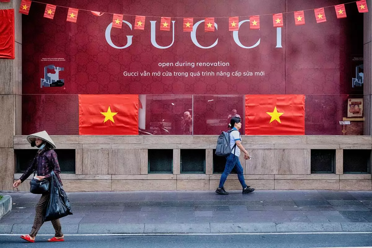 People walk past a Gucci shop in central Ho Chi Minh City, Vietnam, on Tuesday, April 29, 2025 ahead of the 50th anniversary of the end of the Vietnamese War. (AP Photo/Richard Vogel)