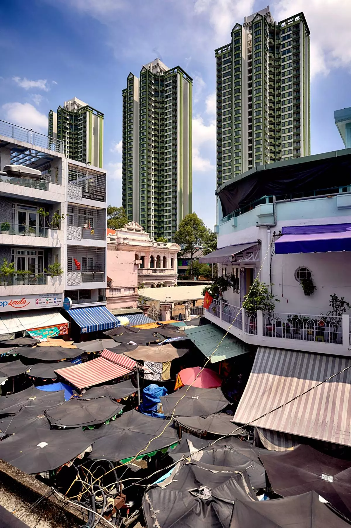 High-rise buildings tower over an umbrella-covered market in the Cholon district of Ho Chi Minh City, Vietnam, Tuesday, April 29, 2025, ahead of the 50th anniversary of the end of the Vietnamese War. (AP Photo/Richard Vogel)