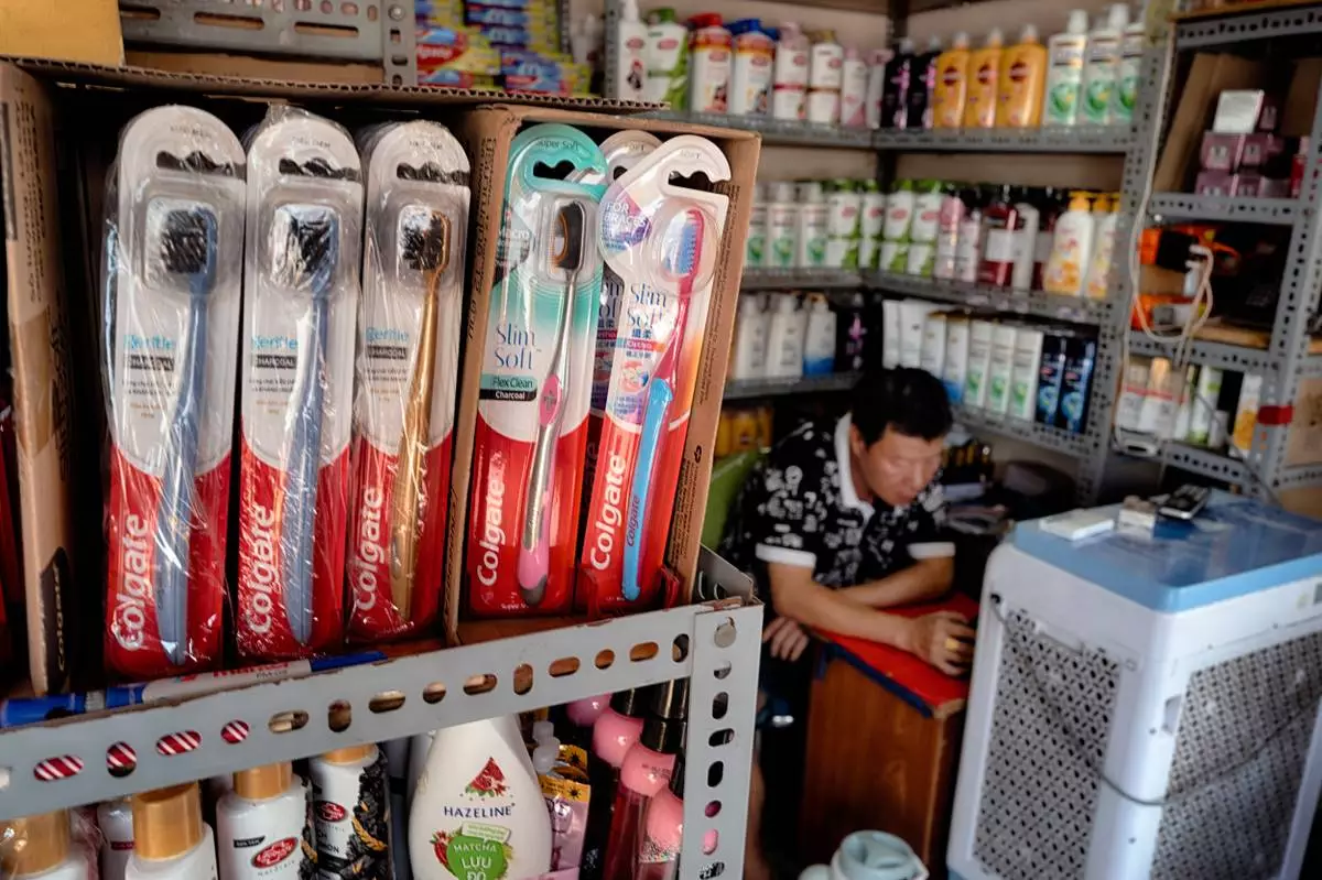 A vendor selling Colgate toothpaste and other U.S. made sundry items waits for customers at the Cholon market in the Cholon district of Ho Chi Minh City, Vietnam, on Tuesday, April 29, 2025 ahead of national celebration of the 50th Anniversary of reunification and the end of the Vietnam War. (AP Photo/Richard Vogel)