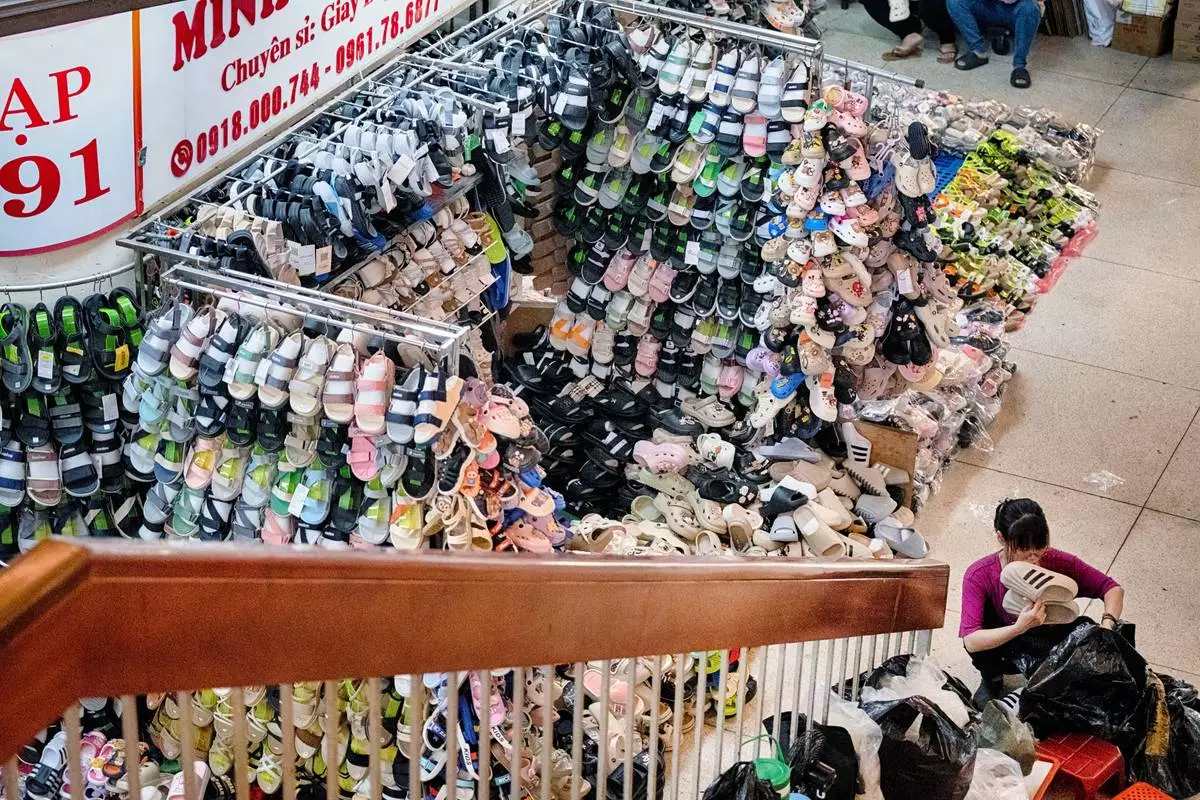 A shoe vendor sets up shop in the morning at the Cholon market in the Cholon district of Ho Chi Minh City, Vietnam, on Tuesday, April 29, 2025 ahead of the 50th anniversary of the end of the Vietnamese War. (AP Photo/Richard Vogel)