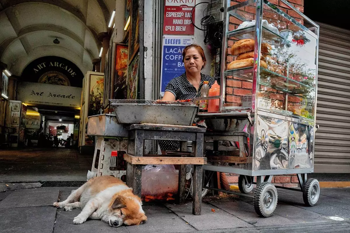 A street vendor grills meat for a Vietnamese Banh Mi sandwich in central Ho Chi Minh City, Vietnam, on Tuesday, April 29, 2025 ahead of the 50th anniversary of the end of the Vietnamese War. (AP Photo/Richard Vogel)