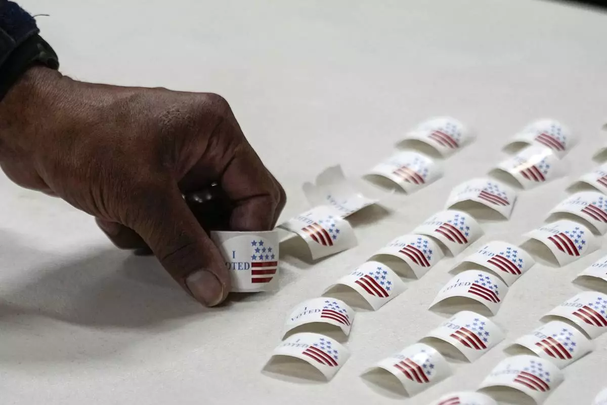 FILE - A voter picks up a sticker after voting at a polling place, March 5, 2024, in Nashville, Tenn. (AP Photo/George Walker IV, File)