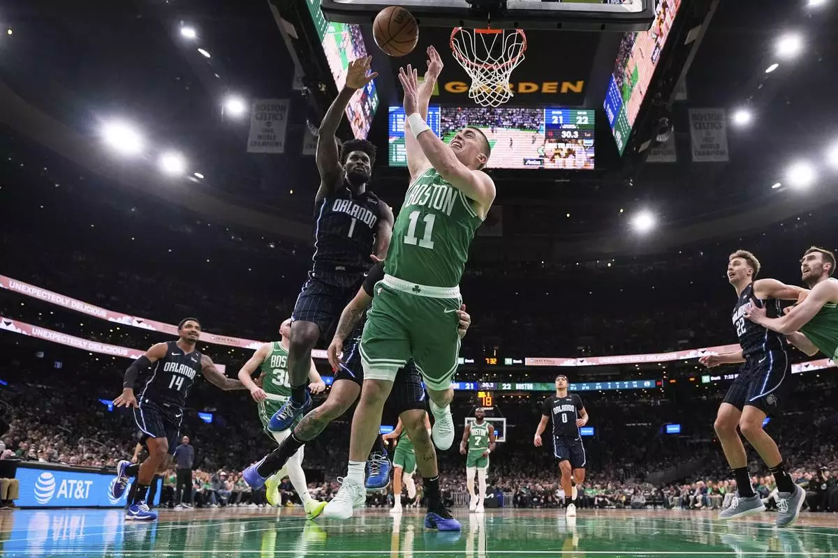 Boston Celtics guard Payton Pritchard (11) is fouled by Orlando Magic guard Anthony Black (0) during the first half in game 2 of a first-round NBA playoff basketball series, Wednesday, April 23, 2025, in Boston. (AP Photo/Charles Krupa)