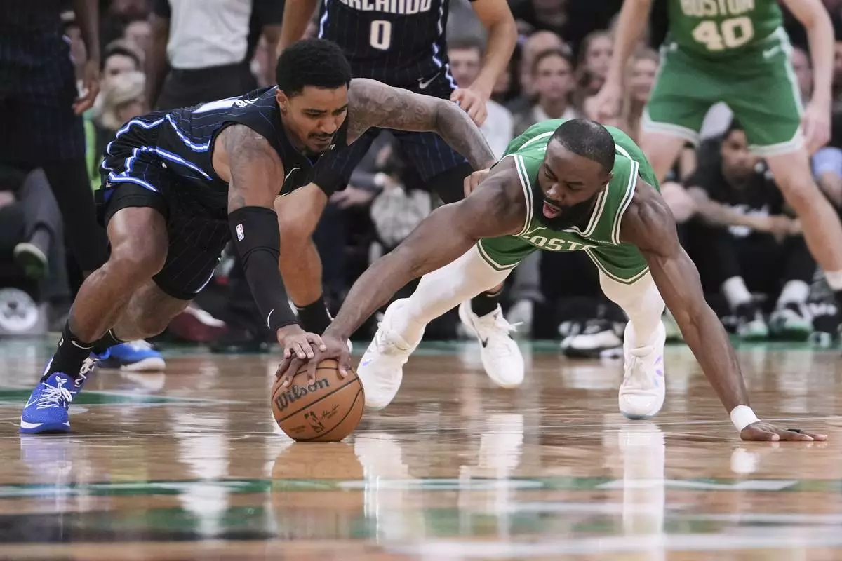Boston Celtics guard Jaylen Brown, right, battles for a loose ball against Orlando Magic guard Gary Harris, left, during the first half in game 2 of a first-round NBA playoff basketball series, Wednesday, April 23, 2025, in Boston. (AP Photo/Charles Krupa)