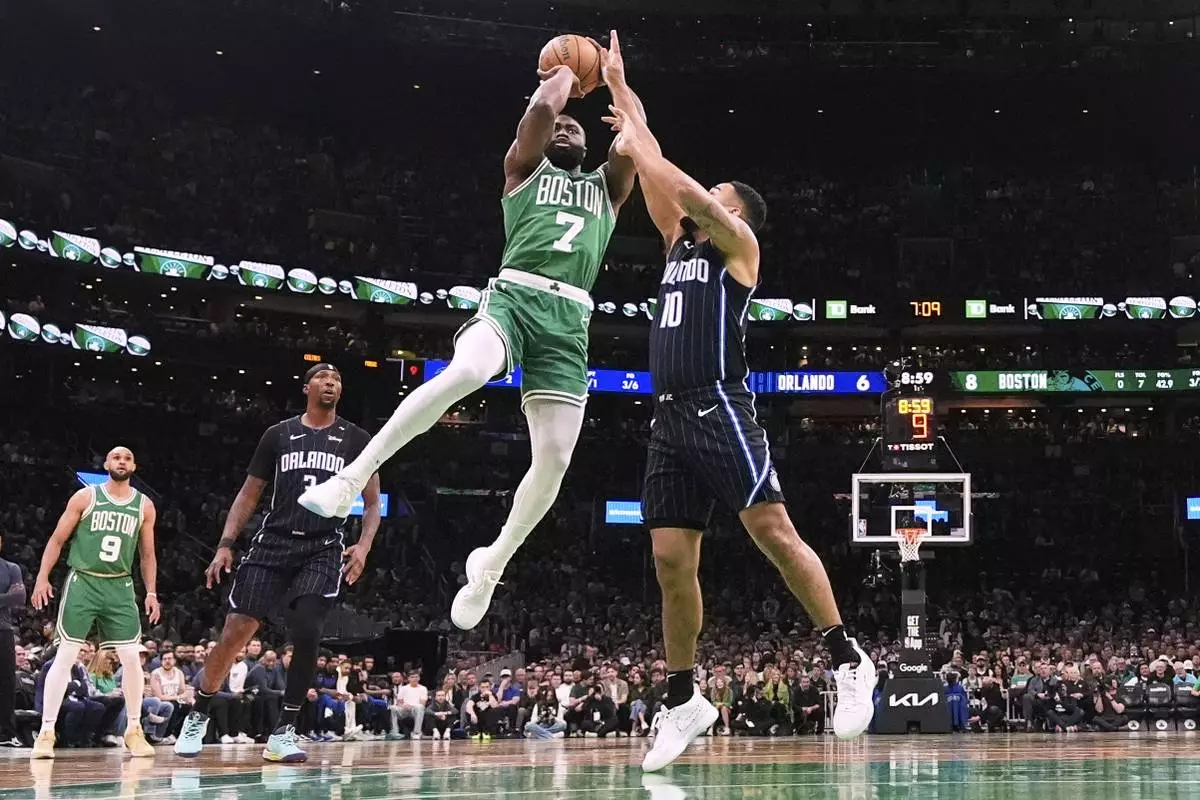 Boston Celtics guard Jaylen Brown (7) takes a shot while pressured by Orlando Magic guard Cory Joseph (10) during the first half in game 2 of a first-round NBA playoff basketball series, Wednesday, April 23, 2025, in Boston. (AP Photo/Charles Krupa)
