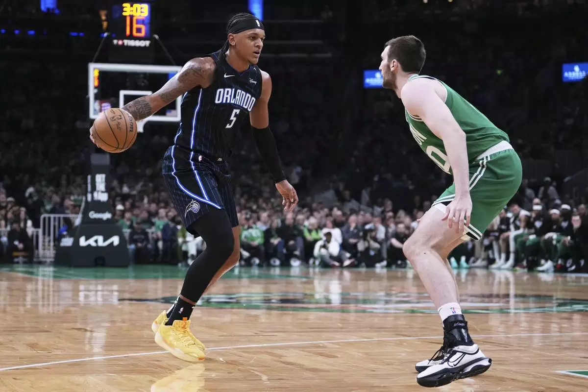 Orlando Magic forward Paolo Banchero (5) drives to the basket against Boston Celtics center Luke Kornet, right, during the first half in game 2 of a first-round NBA playoff basketball series, Wednesday, April 23, 2025, in Boston. (AP Photo/Charles Krupa)
