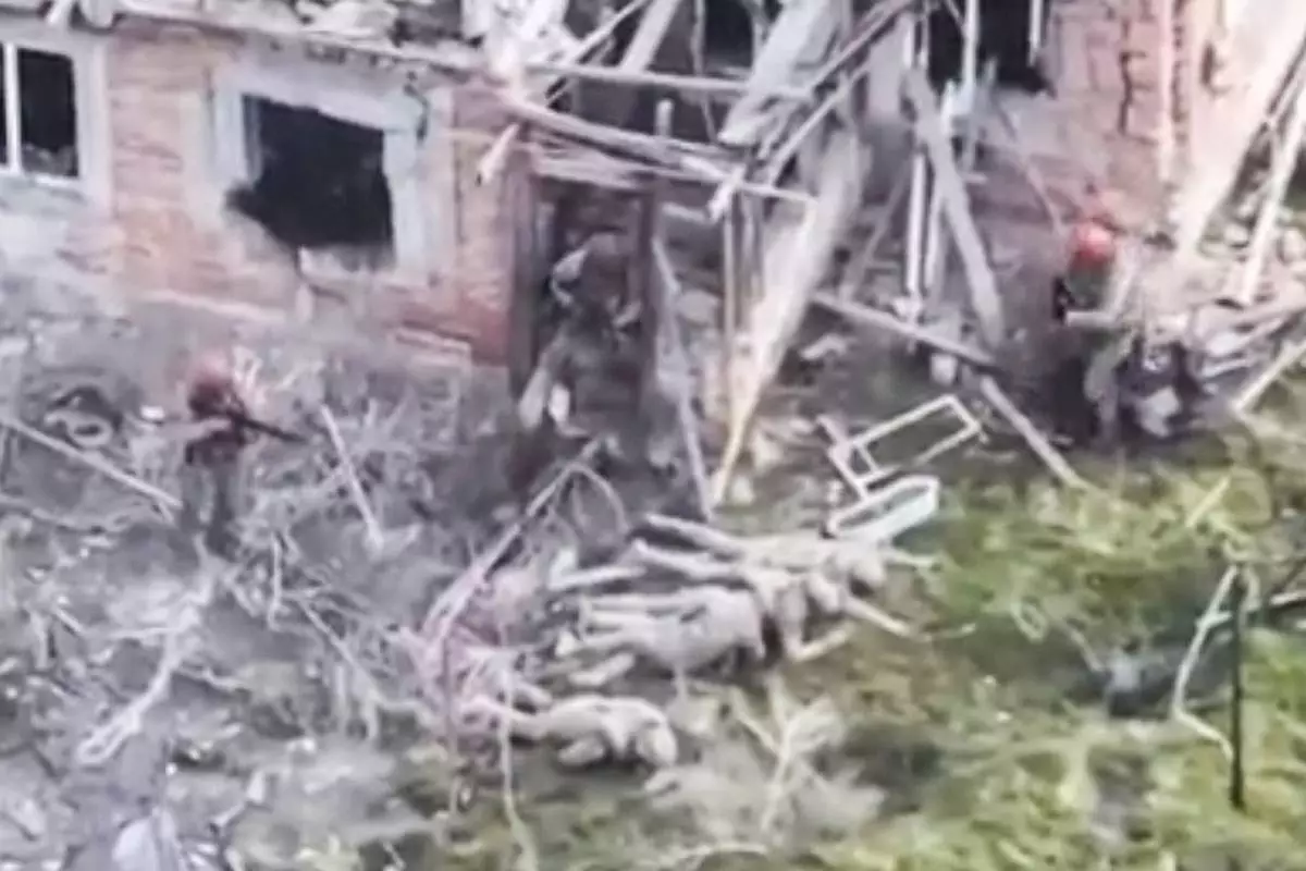 This image taken from video that European military officials say was filmed by a Ukrainian drone in the southern Ukrainian village of Piatykhatky on March 13, 2025, shows three soldiers with red helmets and uniform markings identified as Russian surrounding four Ukrainian soldiers who appear to have surrendered and are laying on the ground. (Ukraine Military/European Defense Officials via AP)