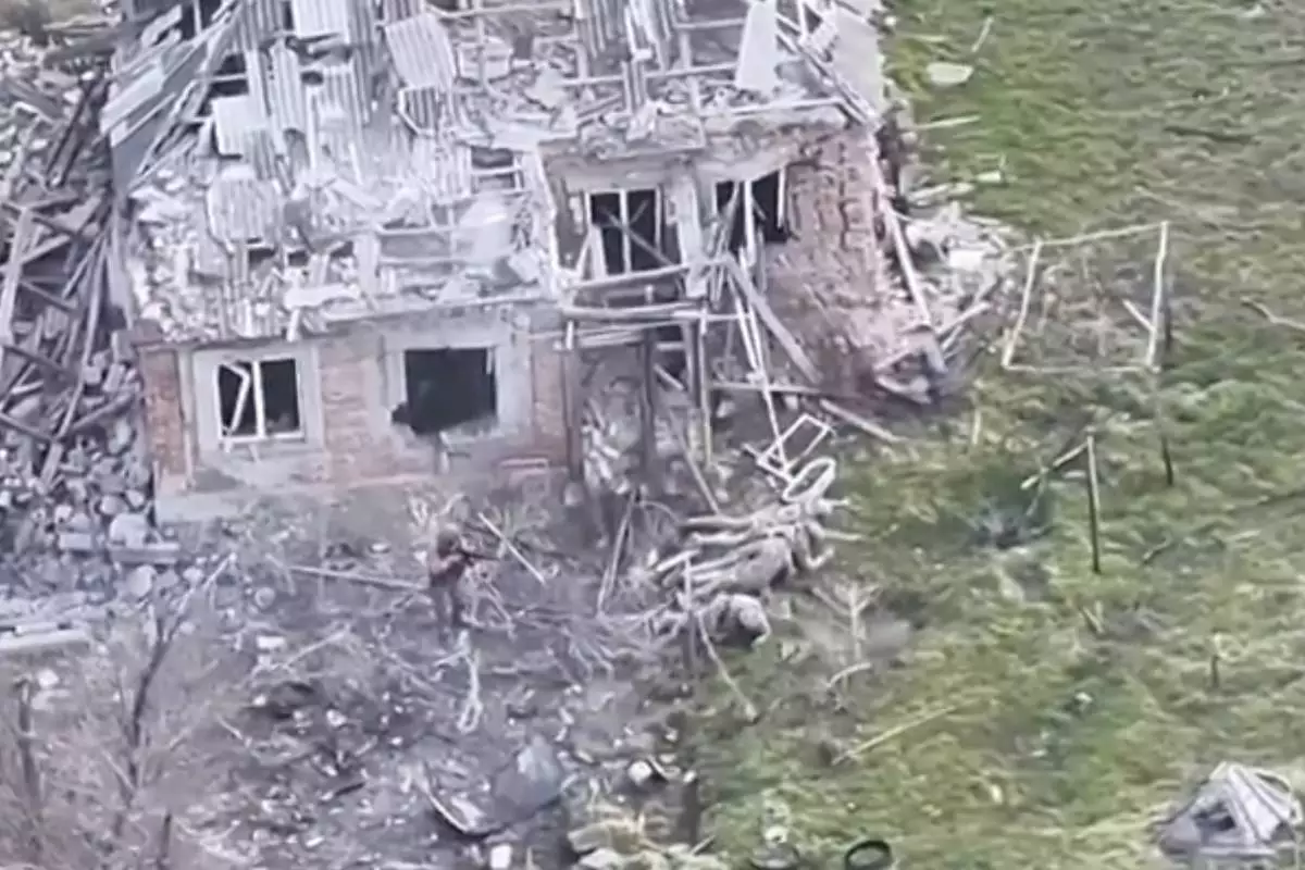 This image taken from video that European military officials say was filmed by a Ukrainian drone in the southern Ukrainian village of Piatykhatky on March 13, 2025, shows a soldier, left, identified as Russian, pointing his gun at four Ukrainian soldiers on the ground who appear to have surrendered. (Ukraine Military/European Defense Officials via AP)