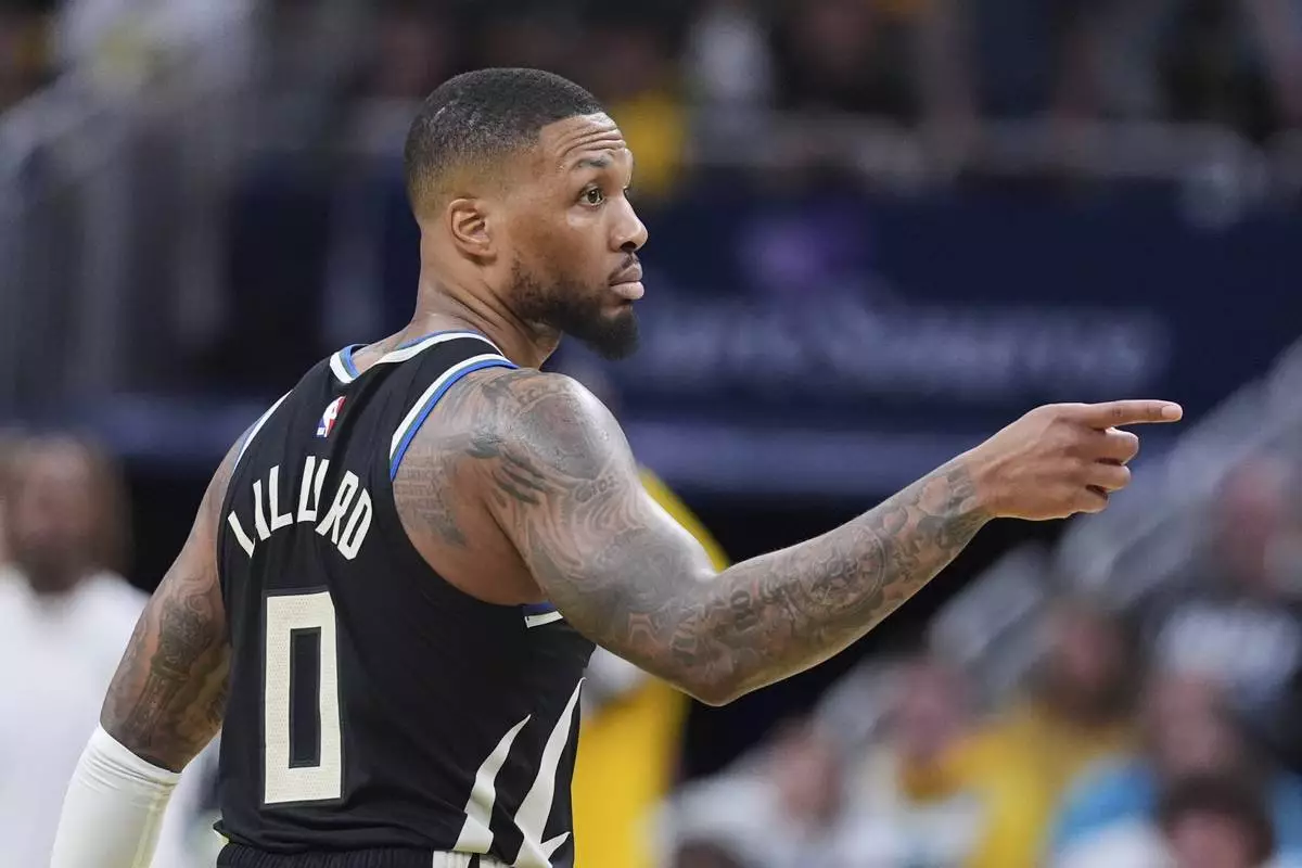 Milwaukee Bucks guard Damian Lillard (0) gestures after a three-point basket against the Indiana Pacers during the second half of a first-round NBA basketball playoff game in Indianapolis, Tuesday, April 22, 2025. (AP Photo/Michael Conroy)